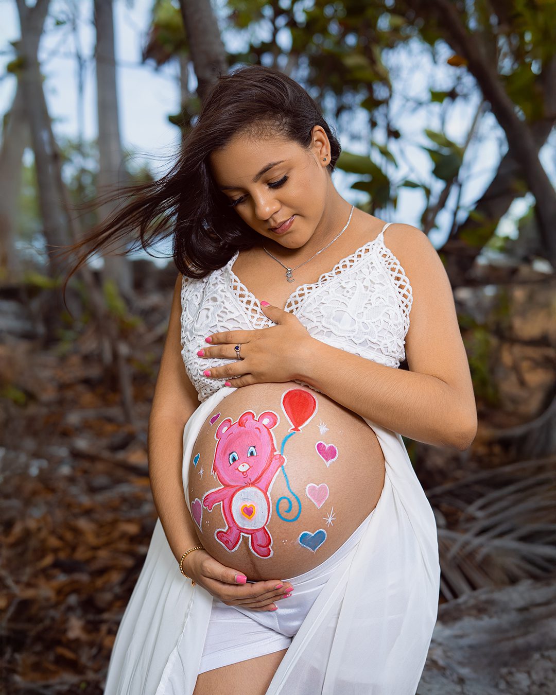Mujer embarazada en sesión de fotos de maternidad en la playa Los Almendros, Baní. Fotografía profesional de embarazo en exterior.